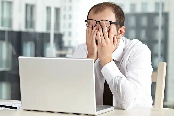 exhausted man in front of his laptop