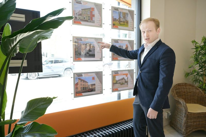 Photo by Md Ishak Rahman - EntreResource.com Real estate agent pointing at property listings in office window