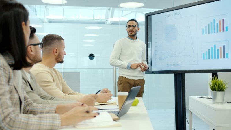 Photo by Vitaly Gariev - EntreResource.com Man presenting charts to colleagues in a meeting